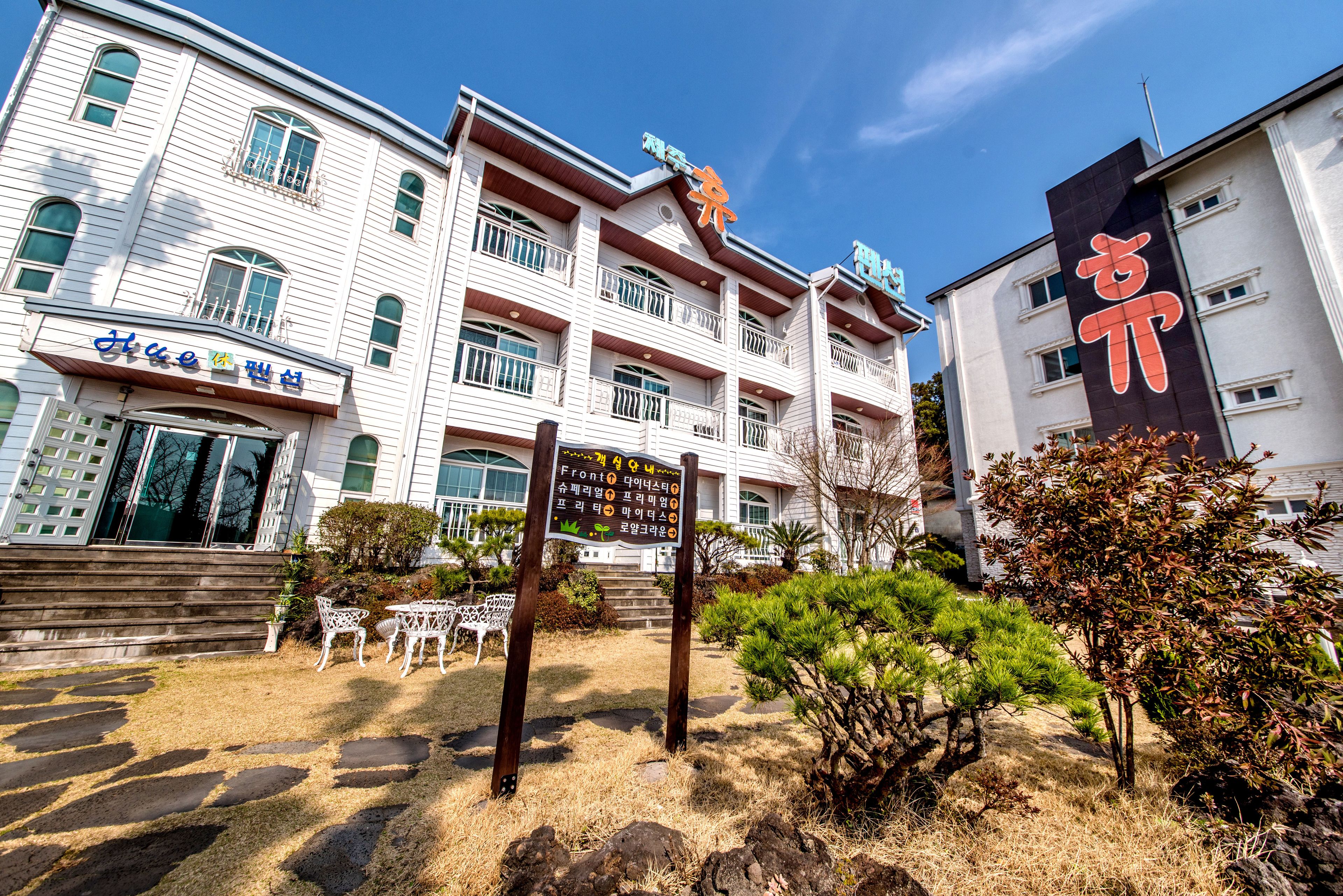 A multi-story building with a signboard in front.