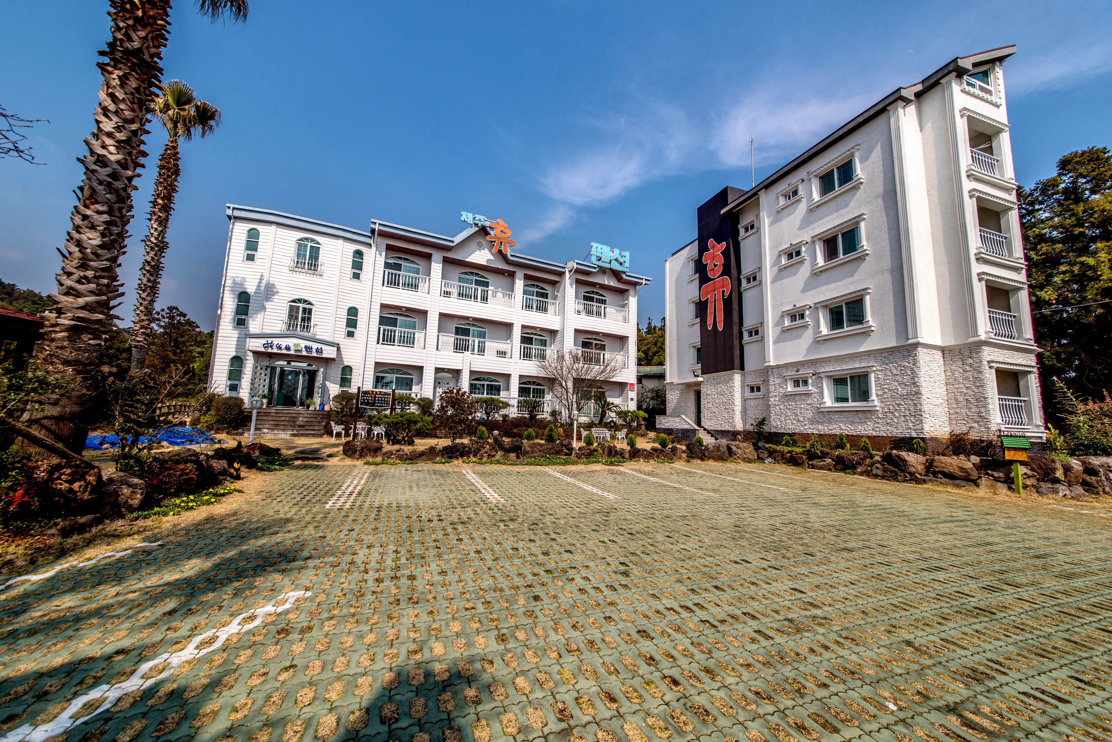 A hotel with a paved courtyard, multiple floors, and balconies.