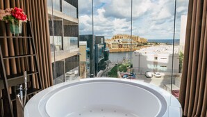 Ein modernes Badezimmer mit einer großen Badewanne, einer Duschkabine aus Glas und Blick auf die Stadtlandschaft.