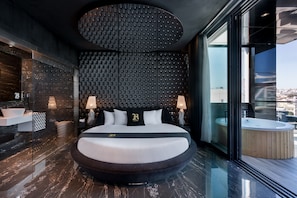 A modern bedroom with a round bed, a large window, and a view of the city. - Hugo's Boutique Hotel - Adults Only (St. Julian's)