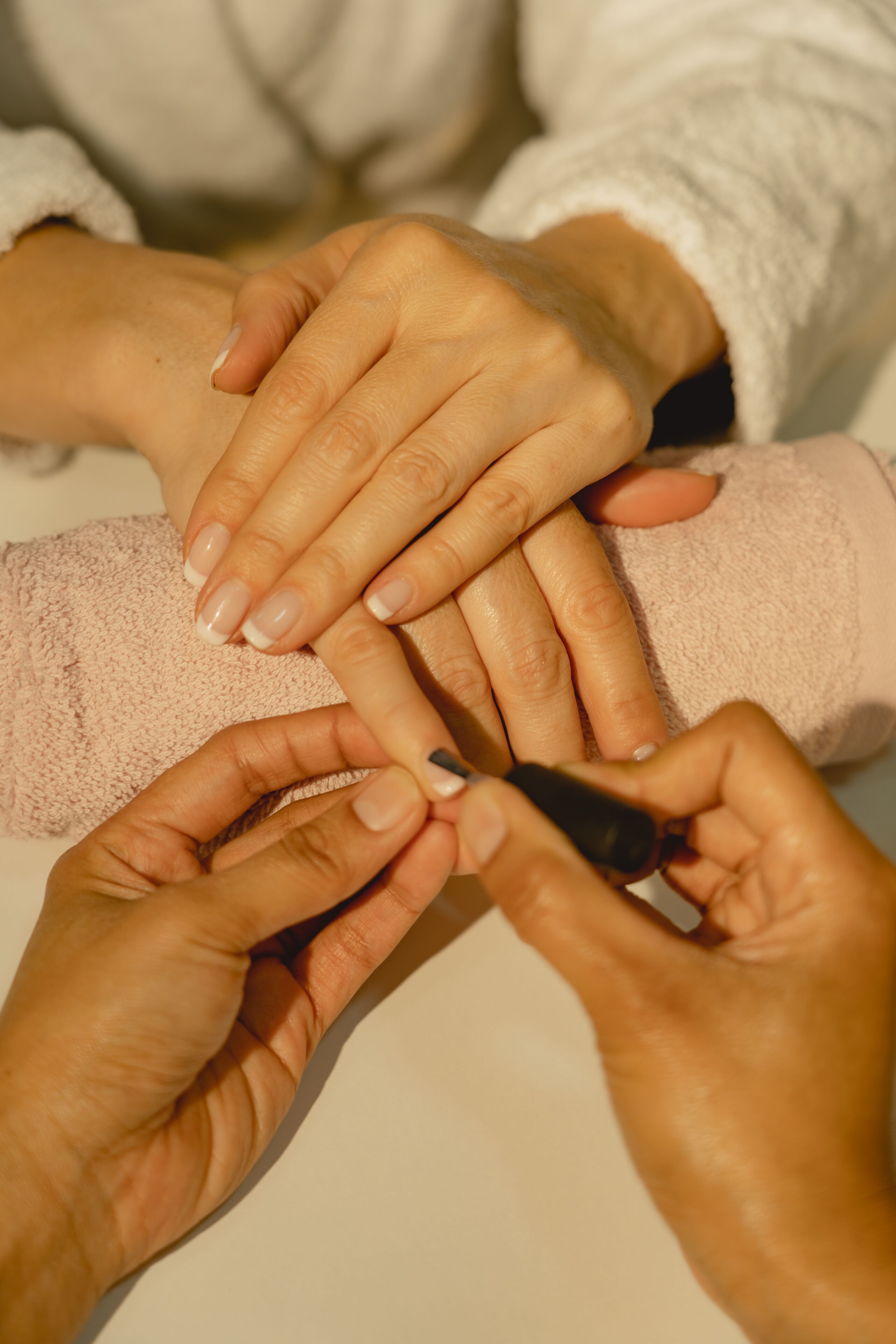 Mãos sendo cuidadas durante uma manicure.