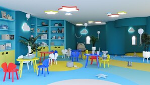 A colorful children's playroom with various toys, chairs, and a bookshelf.