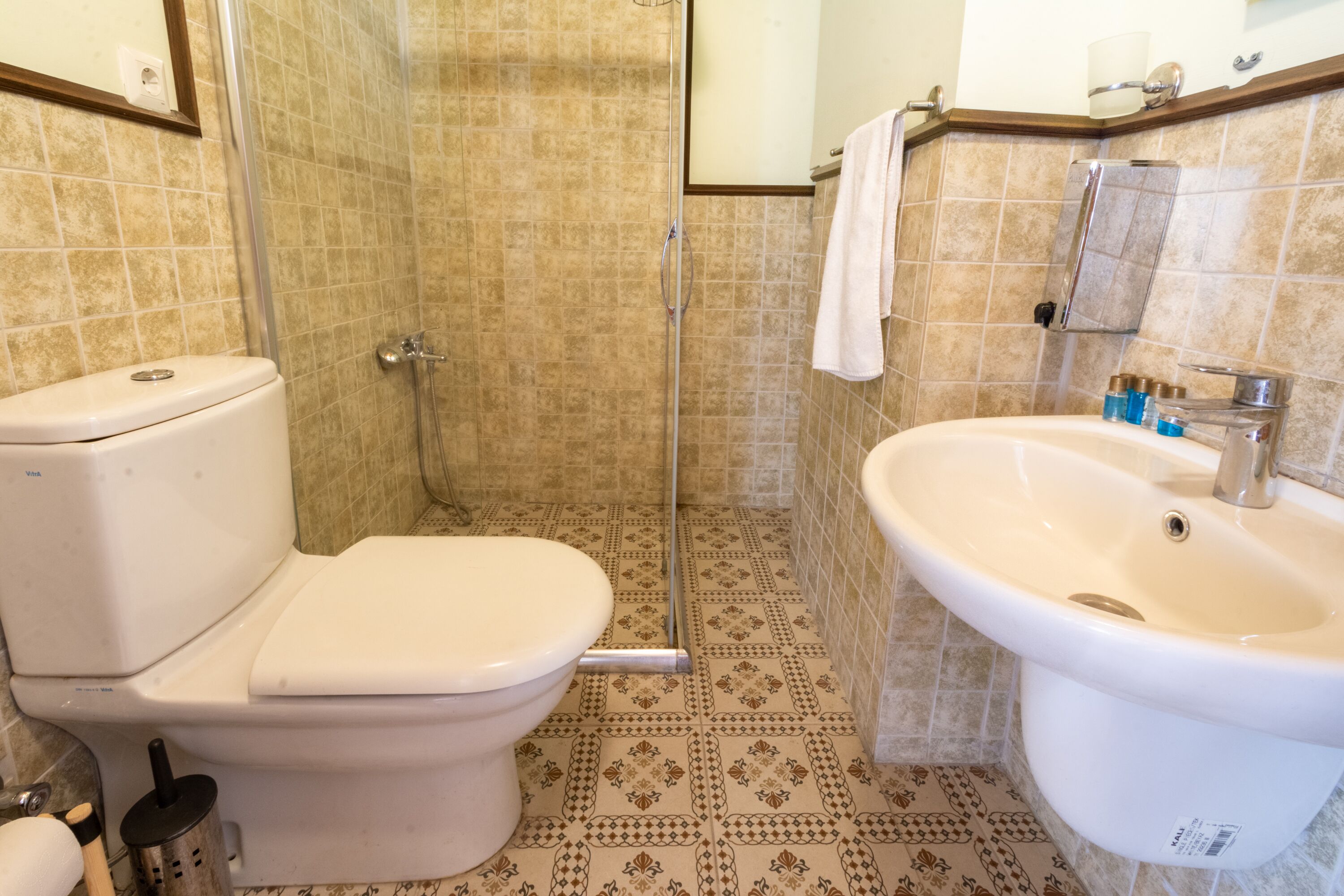 A bathroom with a toilet, shower, and sink.