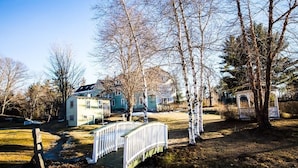 A residential area with a white house, a white bridge, and a gazebo. - Rosewood Country Inn (Bradford)