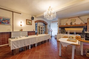 Un'area pranzo con un tavolo lungo, un lampadario e un camino.