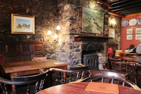 Un interior rústico con paredes de piedra, muebles de madera y una chimenea.