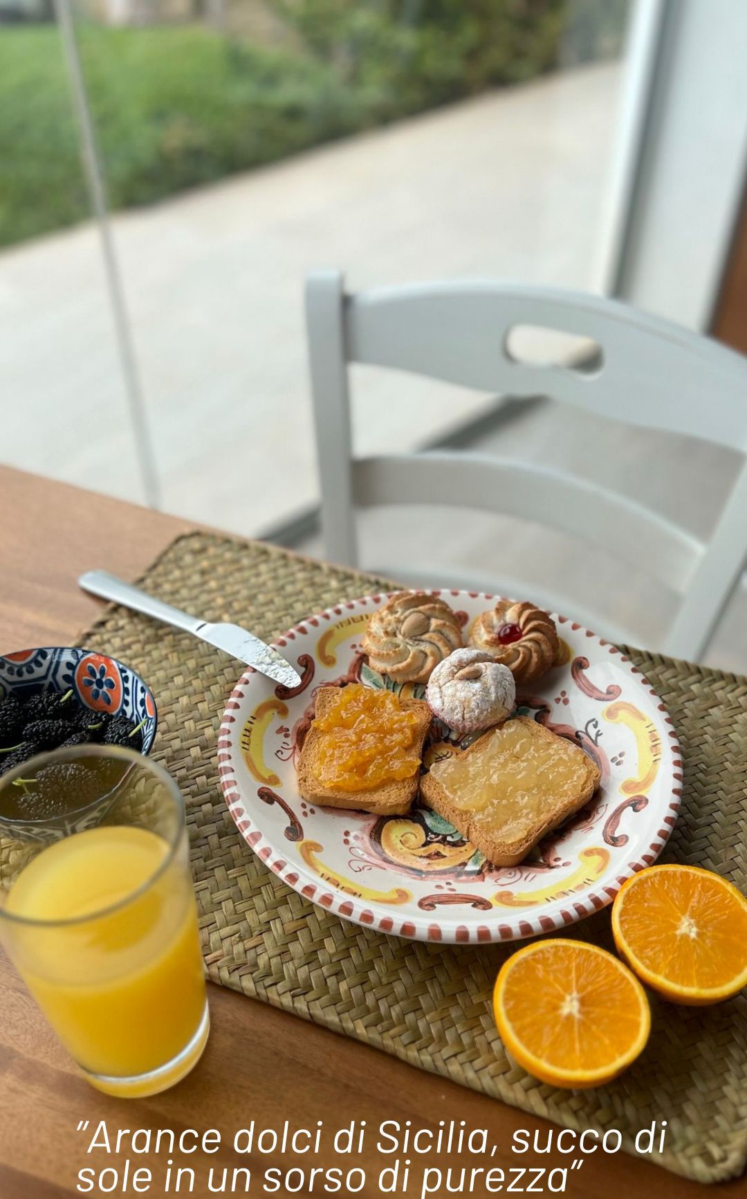 A table with a plate of Sicilian sweets and a glass of orange juice.