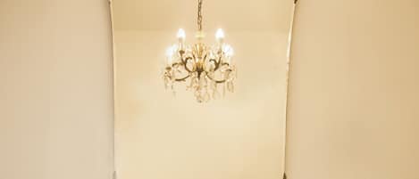 A bathroom with a white sink, a chandelier, a key, and toiletries.