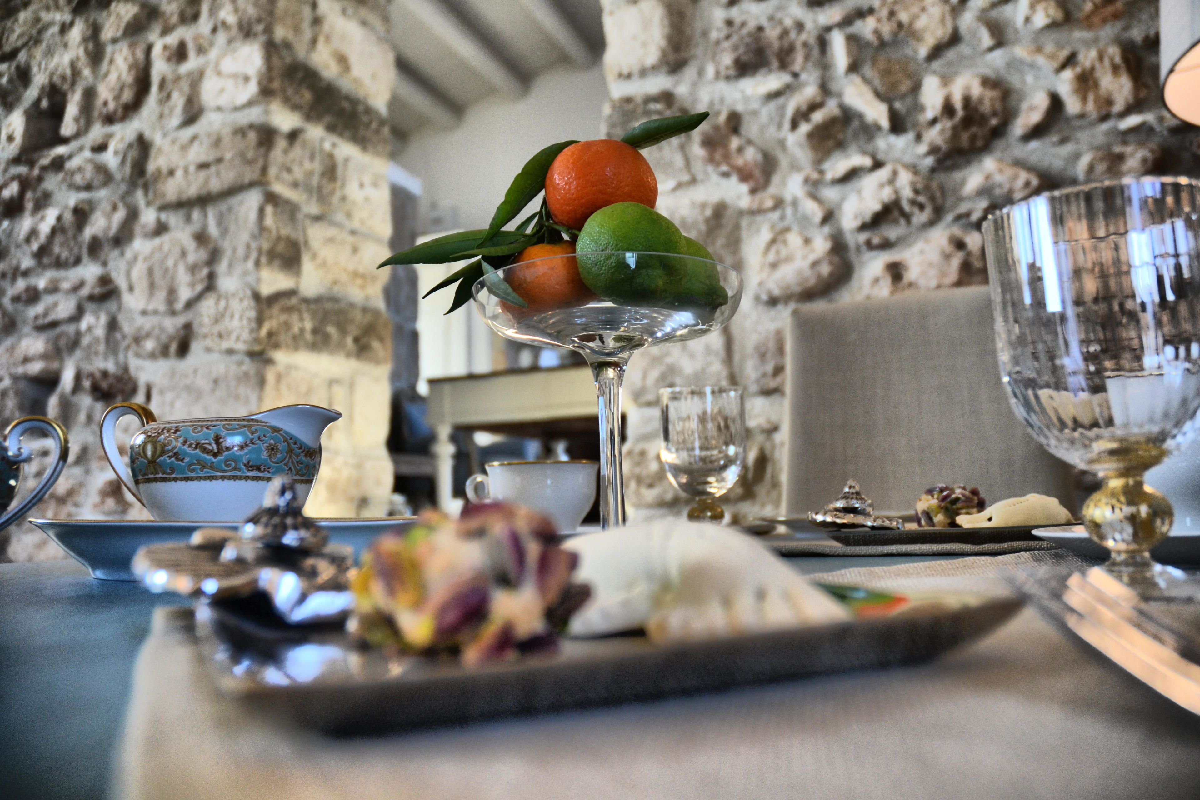 A table with a plate of food, a glass of water, and a decorative pitcher.