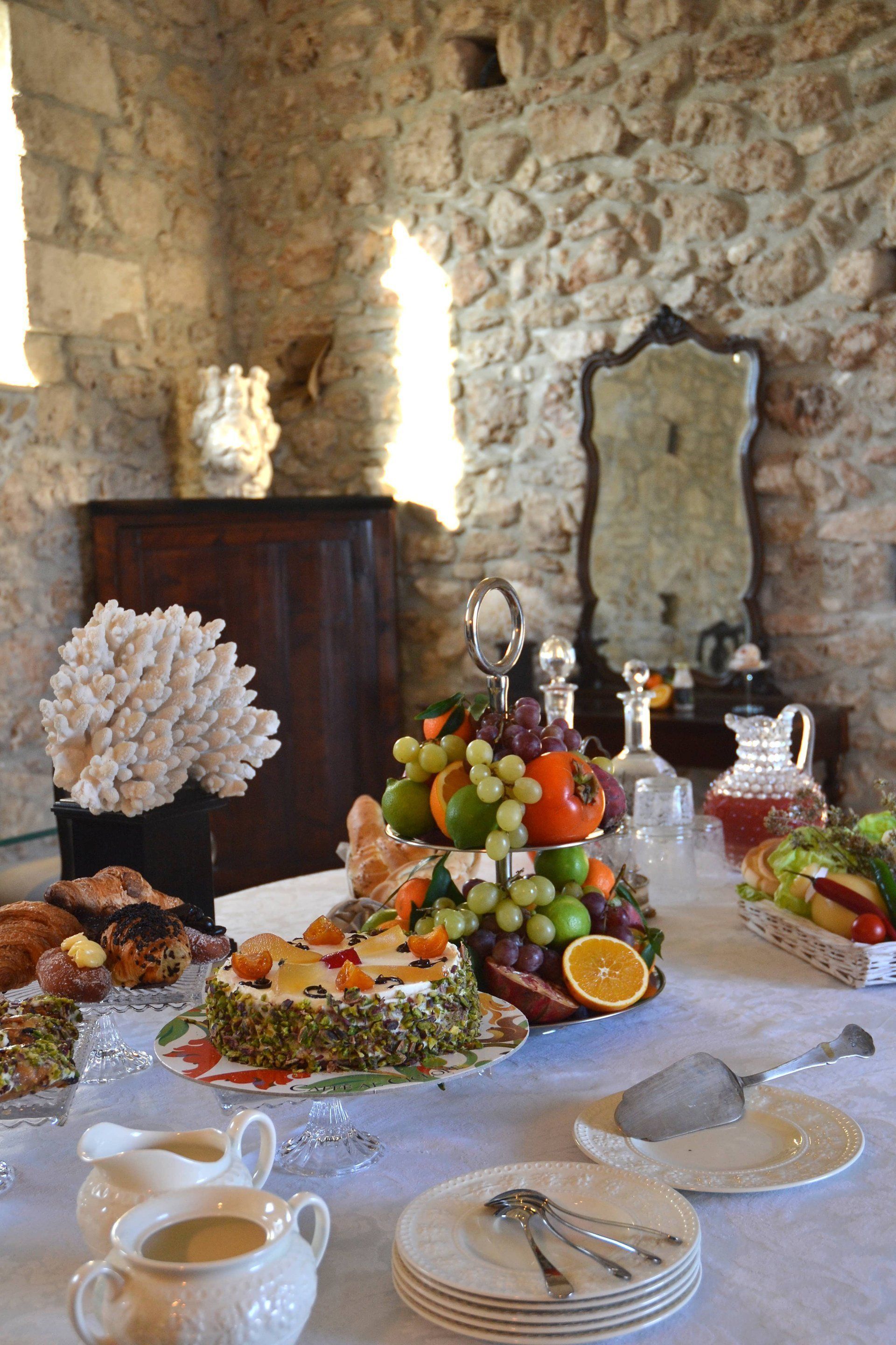 Mesa posta com diferentes tipos de comida e um centro de mesa decorativo.