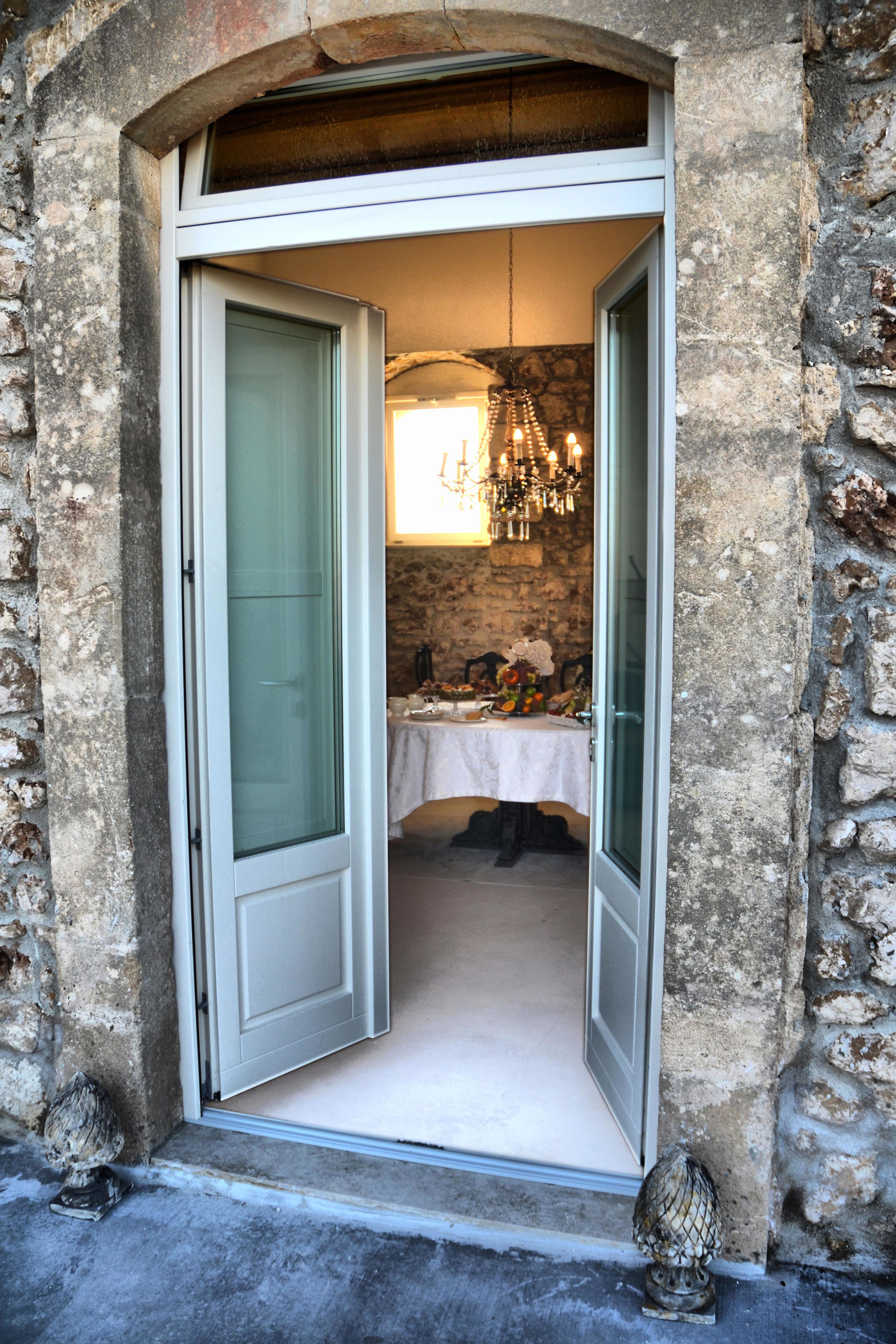 A doorway leading to a room with a table set for dining, a chandelier, and a decorative item on the floor.