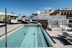 A rooftop pool area with lounge chairs, a small pool, and a view of the cityscape. - Catalonia Magdalenes (Barcelona)