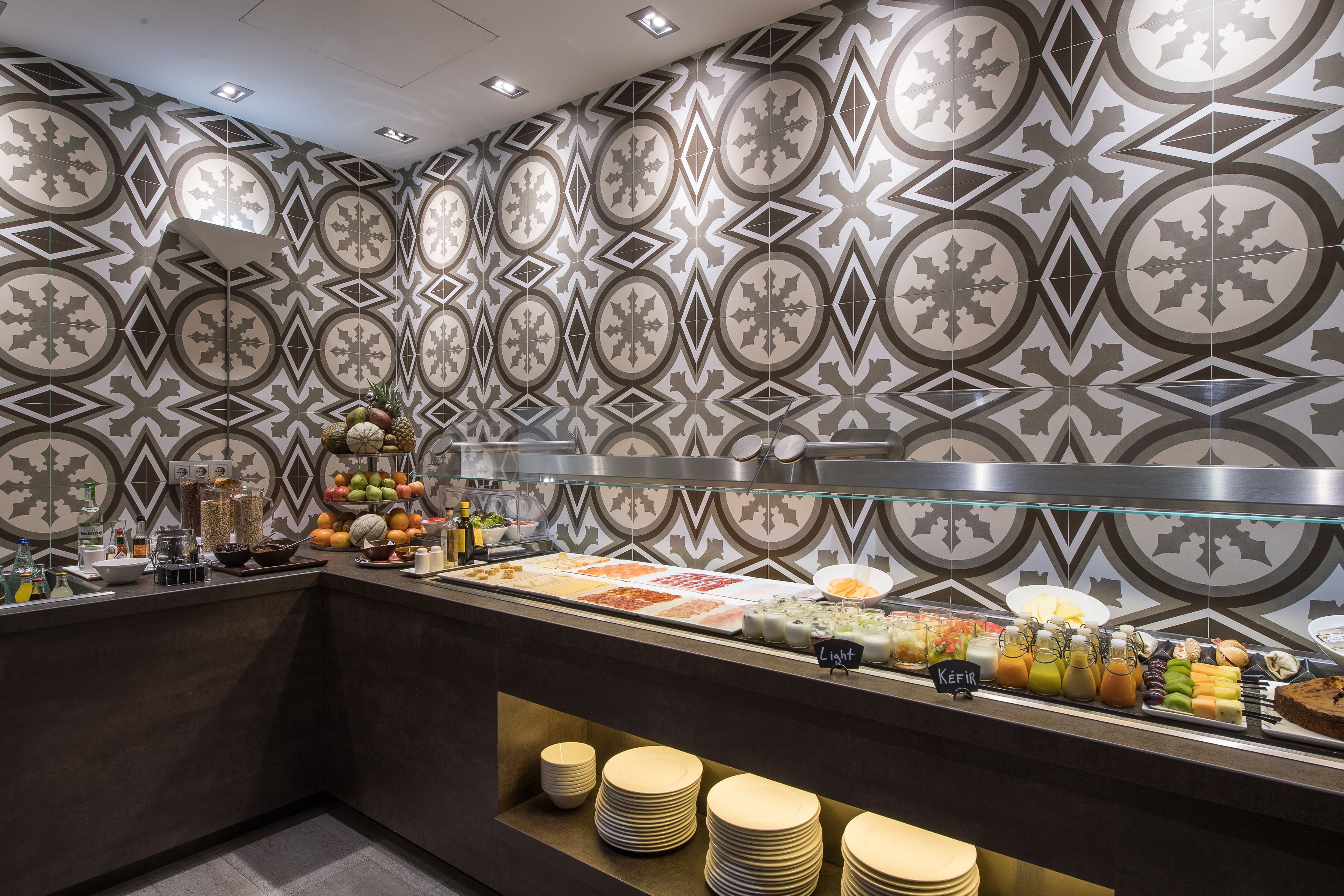 Un área de bufé con pared estampada y una variedad de alimentos.