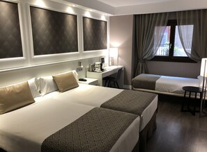 A hotel room with a large bed, a smaller bed, a desk, and a chair. - Catalonia Magdalenes (Barcelona)