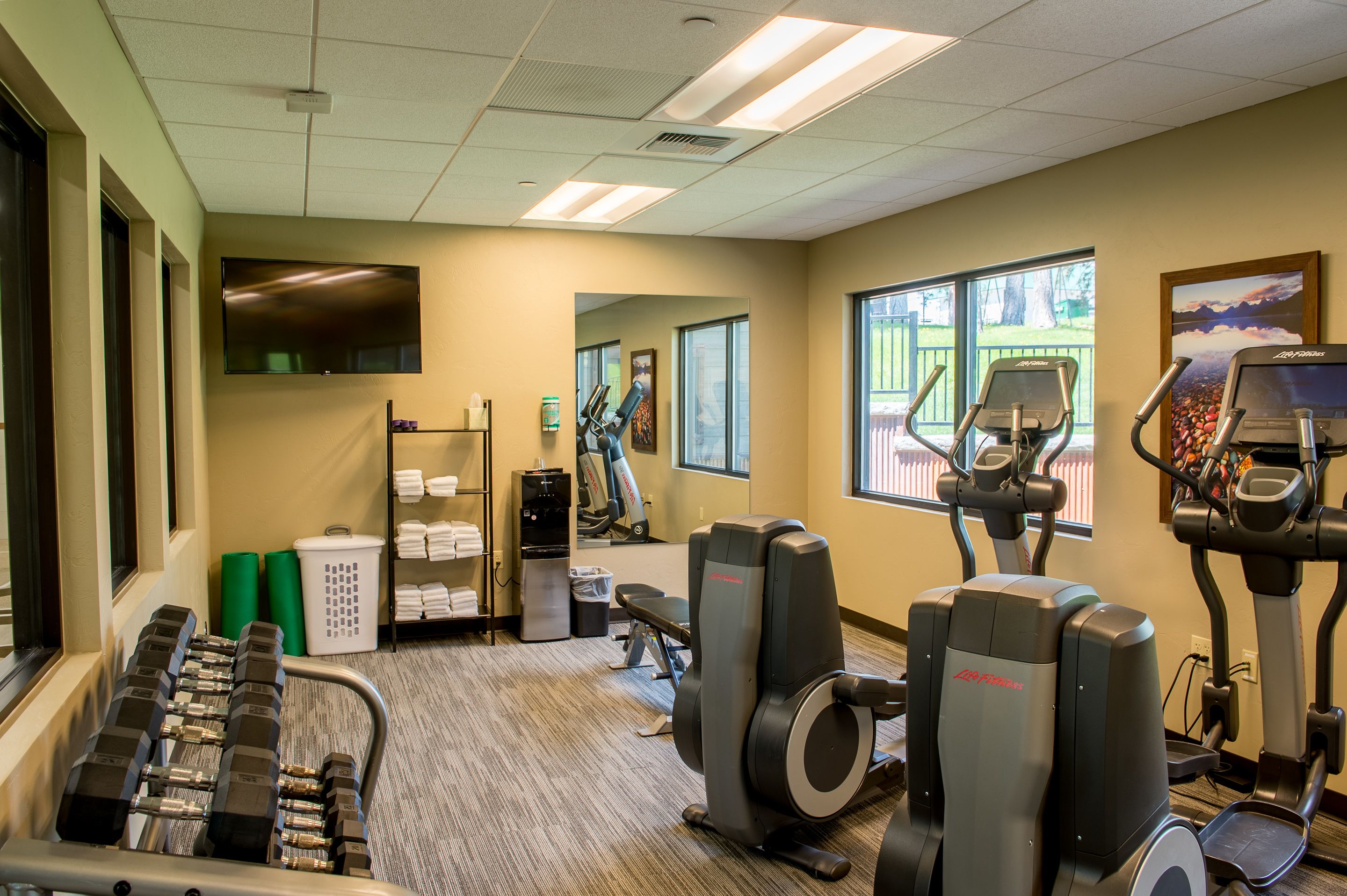 A gym with treadmills, elliptical machines, and weight machines.
