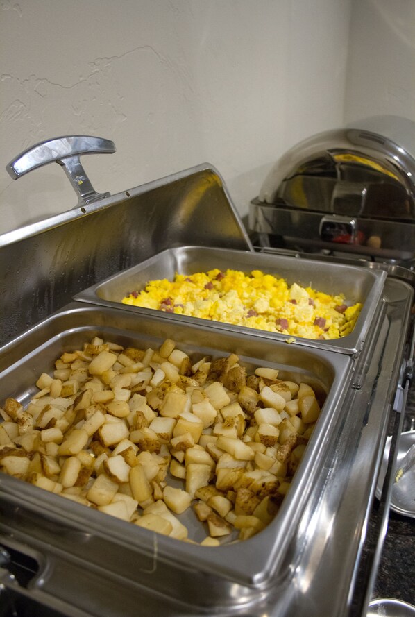 A buffet with various food items including scrambled eggs and diced potatoes.