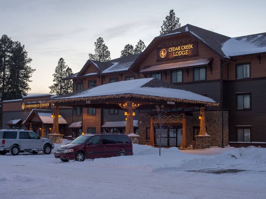 A lodge with a covered entrance, a sign reading "Cedar Creek Lodge," and a Conference Center sign.