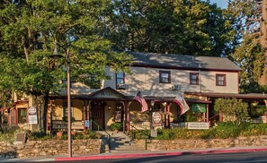 A historic hotel with a traditional facade, a front porch, and a sign indicating special rates mid-week savings. - Julian Gold Rush Hotel (Julian)