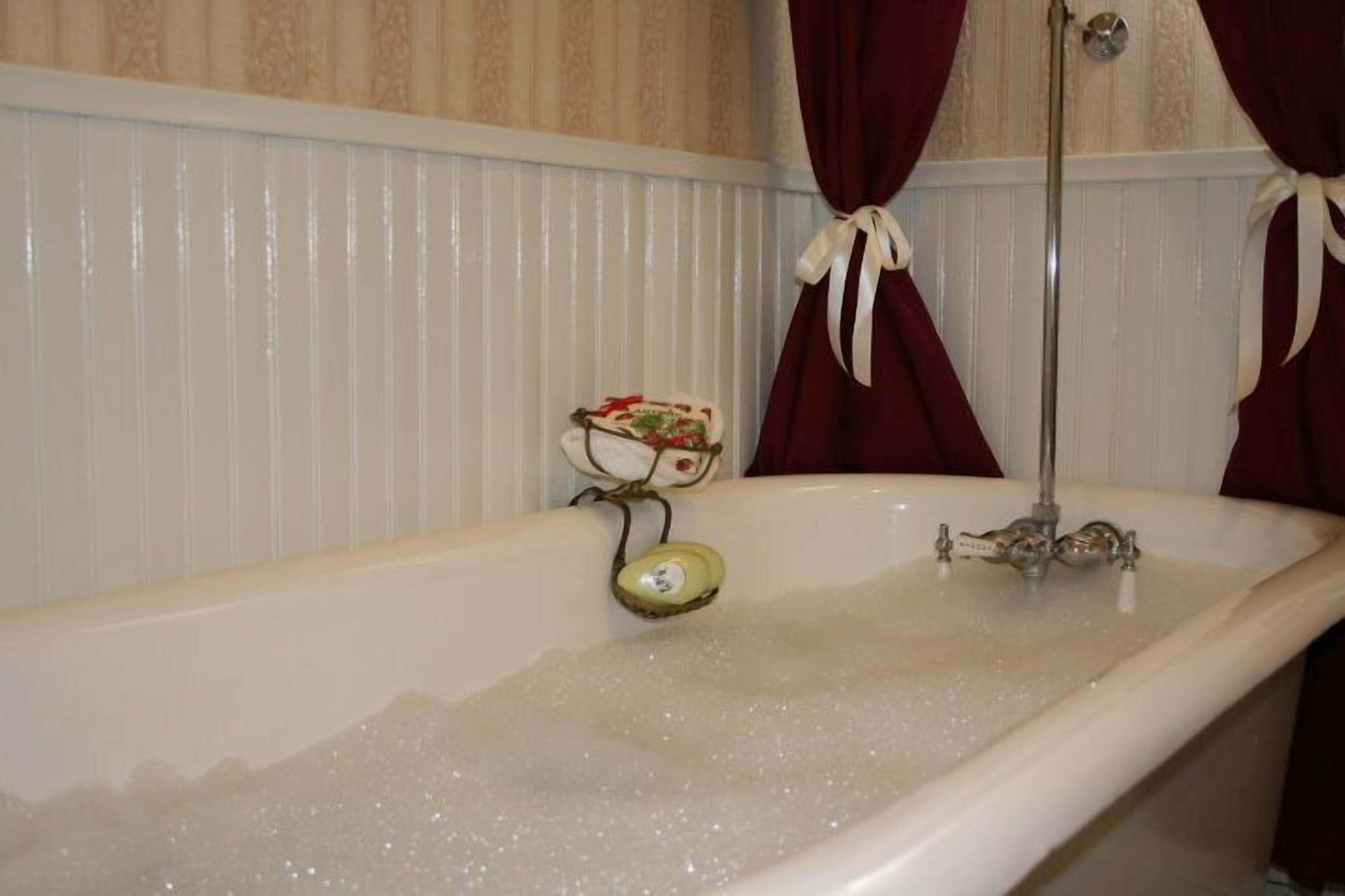 A bathtub with a faucet and a soap dish.
