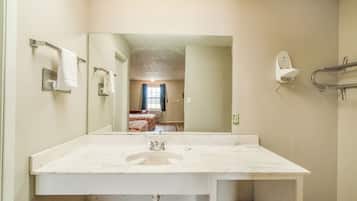 A bathroom with a large mirror, a white sink, and a towel rack.
