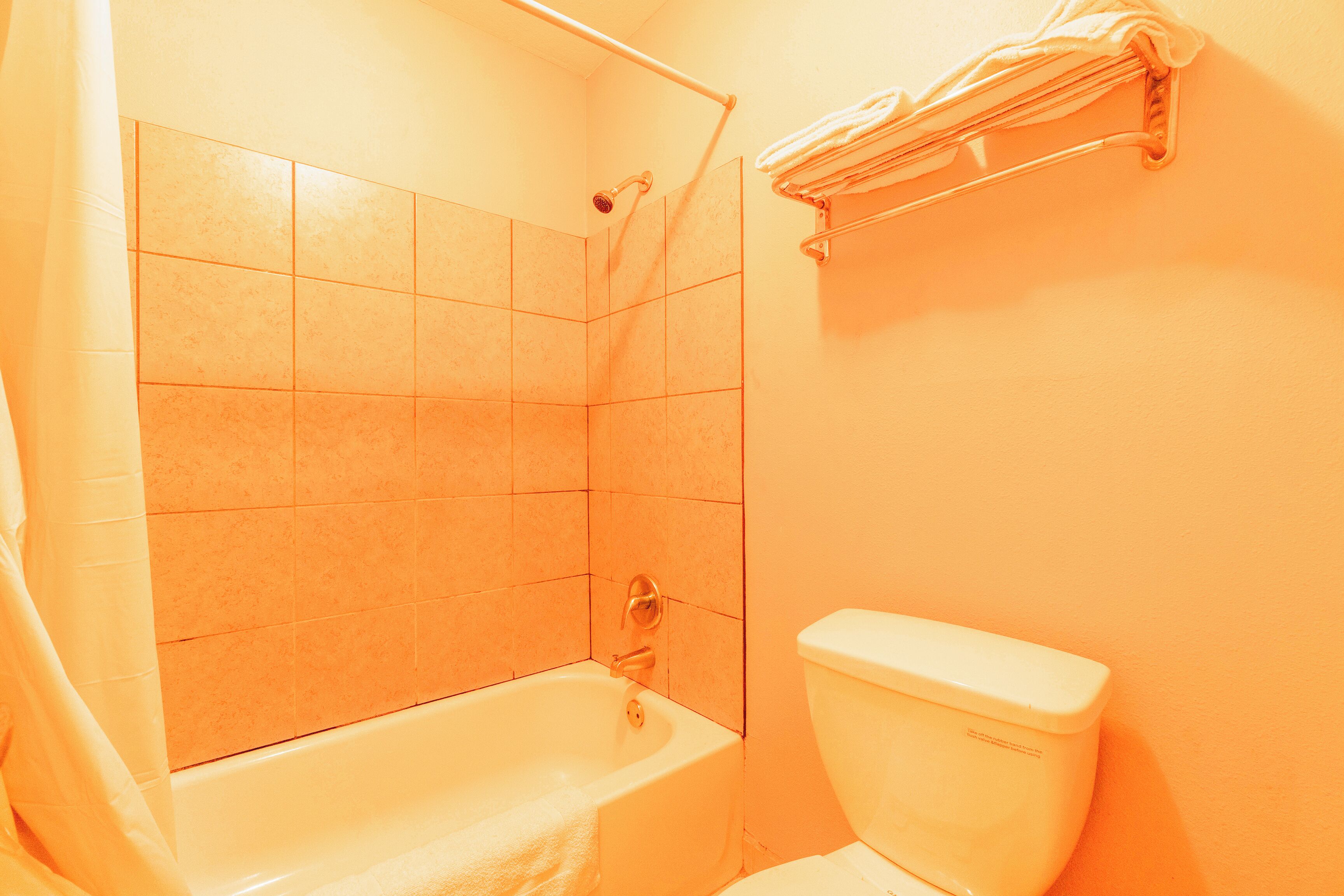 A bathroom with a bathtub, shower, and toilet.