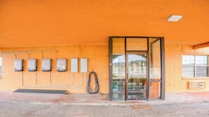 A building with a brick facade, a glass entrance, and several electrical boxes on the wall. - Executive Inn By OYO Mineral Wells US-180 (Mineral Wells)