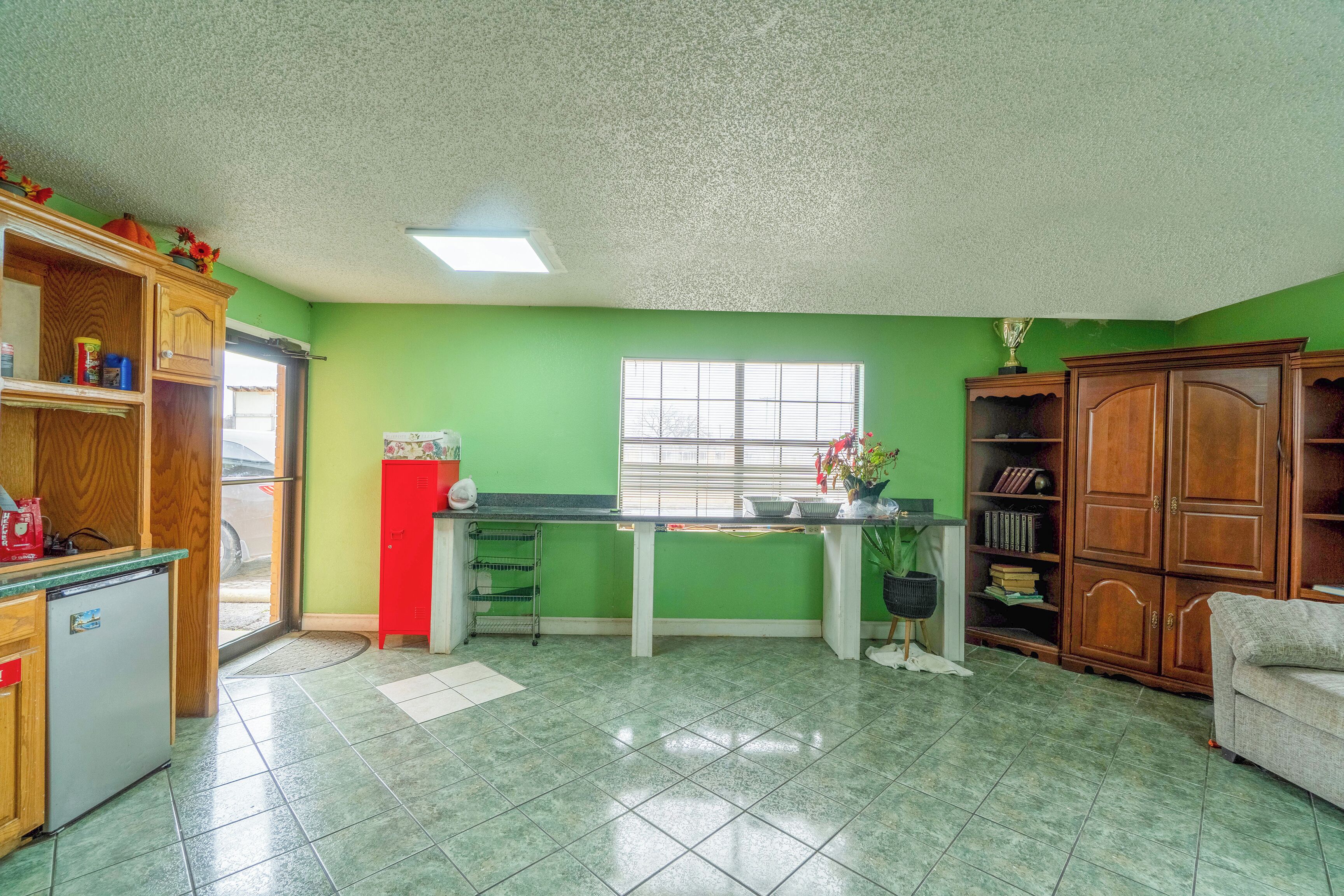 Una cocina con refrigerador, pileta y armarios de madera.