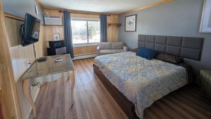 A bedroom with a bed, a desk, a TV, and a window. -  Random Lake Motel (RLM) (Random Lake)
