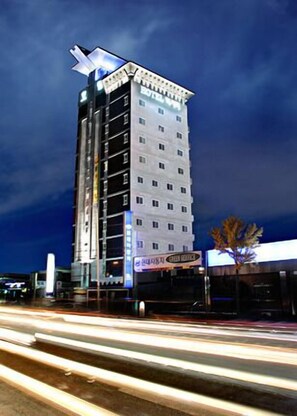 Un hotel alto con varios pisos y una estructura superior distintiva.