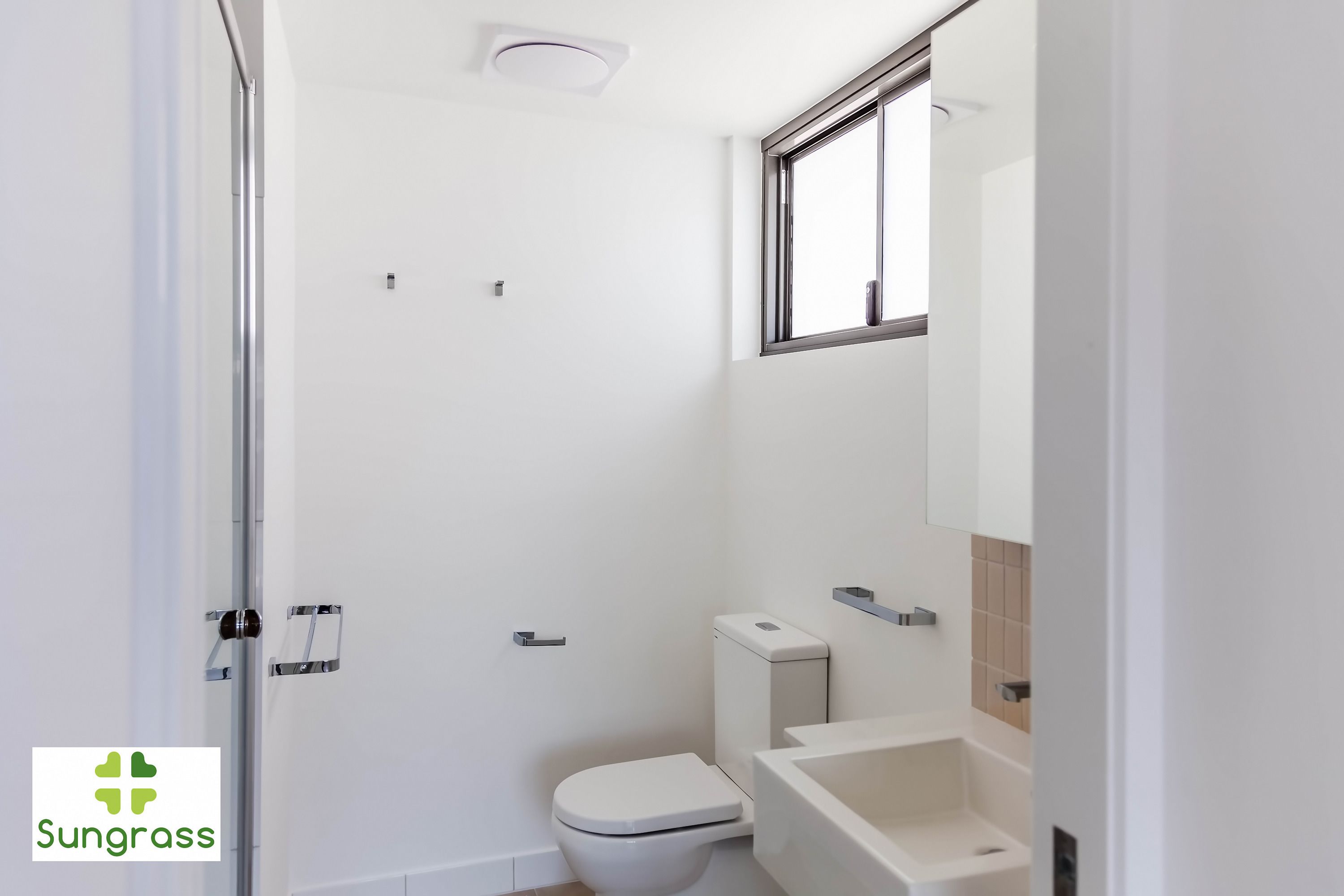 A modern bathroom with a toilet, sink, and shower.