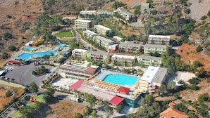 Vue aérienne d’un complexe hôtelier doté de plusieurs piscines, d’un parc aquatique et de différents bâtiments d’hôtel.