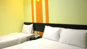 Ein Hotelzimmer mit zwei Betten, jeweils mit weißer Bettwäsche und Kissen. Auf dem Nachttisch zwischen den Betten steht ein Telefon. Die Wände sind hellgrün gestrichen mit einem orangefarbenen Streifenmuster.