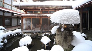 Un edificio japonés tradicional con interior de madera y exterior cubierto de nieve.
