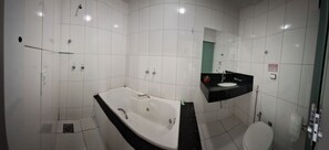 A bathroom with a white bathtub, a black sink, and a toilet. - Hotel Redentor (Santa Vitoria)