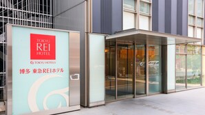 The exterior of the Tokyo Rei Hotel, featuring a modern facade with large glass windows and a prominent signage.
