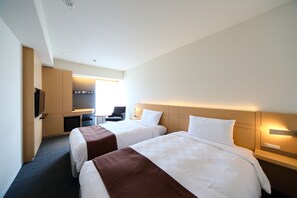 Een hotelkamer met twee bedden, een bureau, een stoel en een televisie.