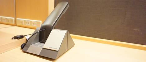 A modern desk with a sleek, metallic device on it, possibly a charging station, with a label that reads "BANG & OLIFSEN".