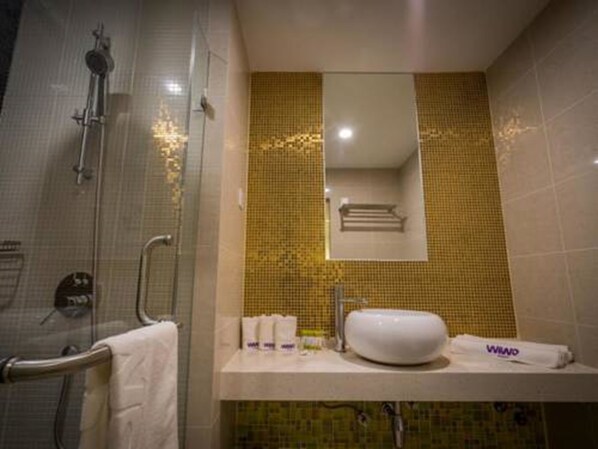 A bathroom with a shower, a sink, and a mirror. - Wiwo Hotels (Bintulu)