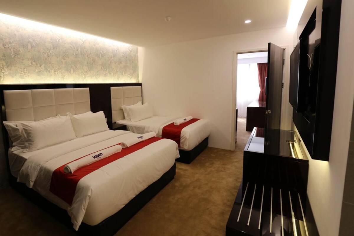 Une chambre d’hôtel avec deux lits, une télévision et un minibar.