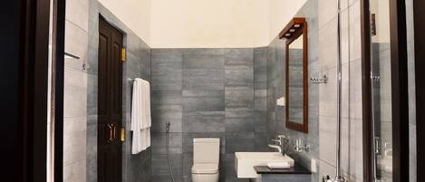 A modern bathroom with a toilet, sink, and shower.