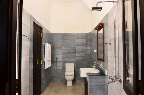 A modern bathroom with a toilet, sink, and shower. - 56 by Deco (Galle)