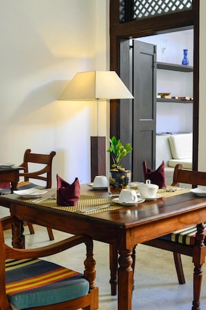 Enjoy a romantic dinner for two in this cozy dining area, complete with a beautifully set table and a lovely potted plant.