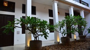 A building with white columns, potted plants, and a balcony. - 56 by Deco (Galle)