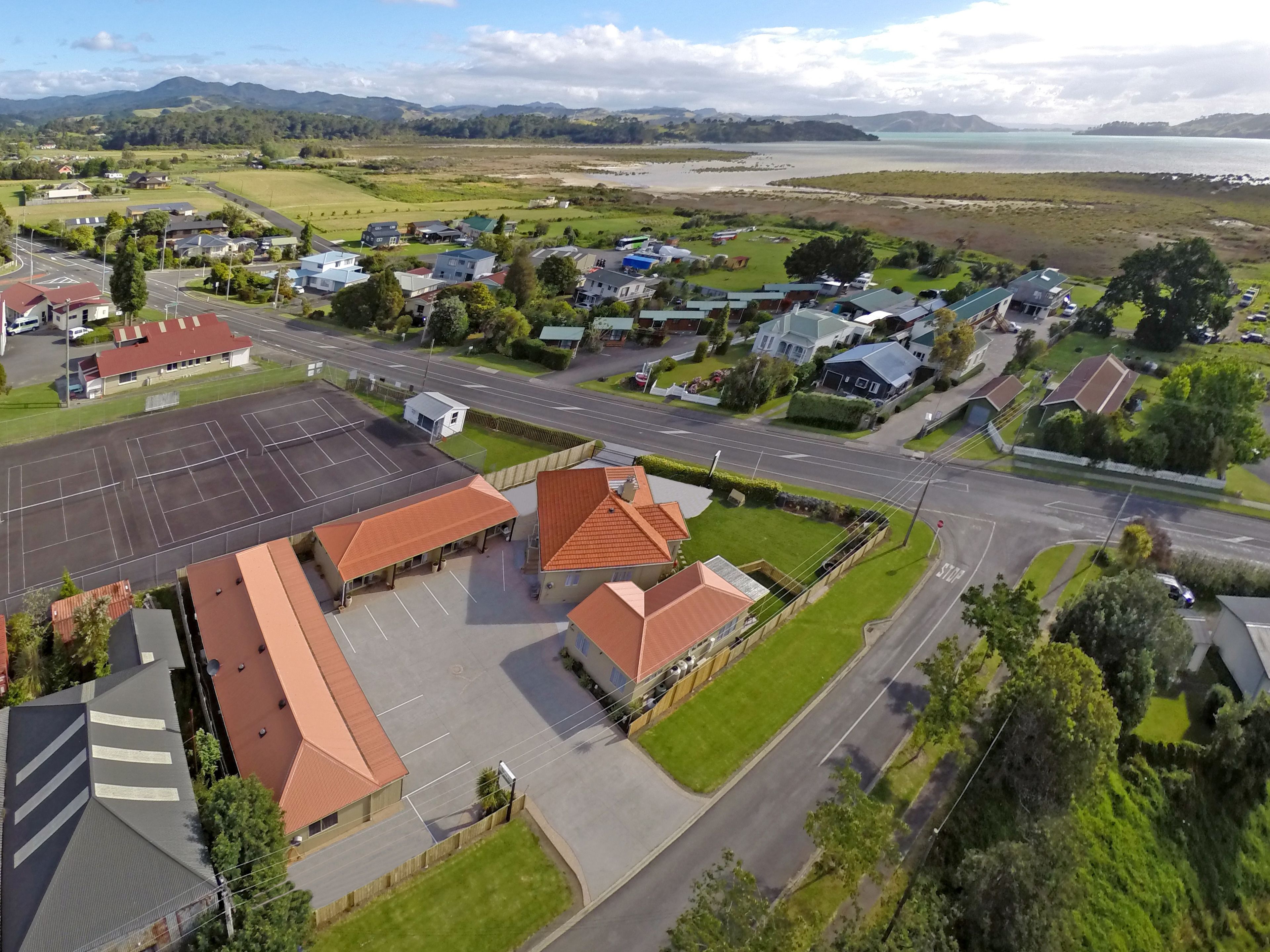 An aerial view of a residential area with houses, a parking lot, and a road.
