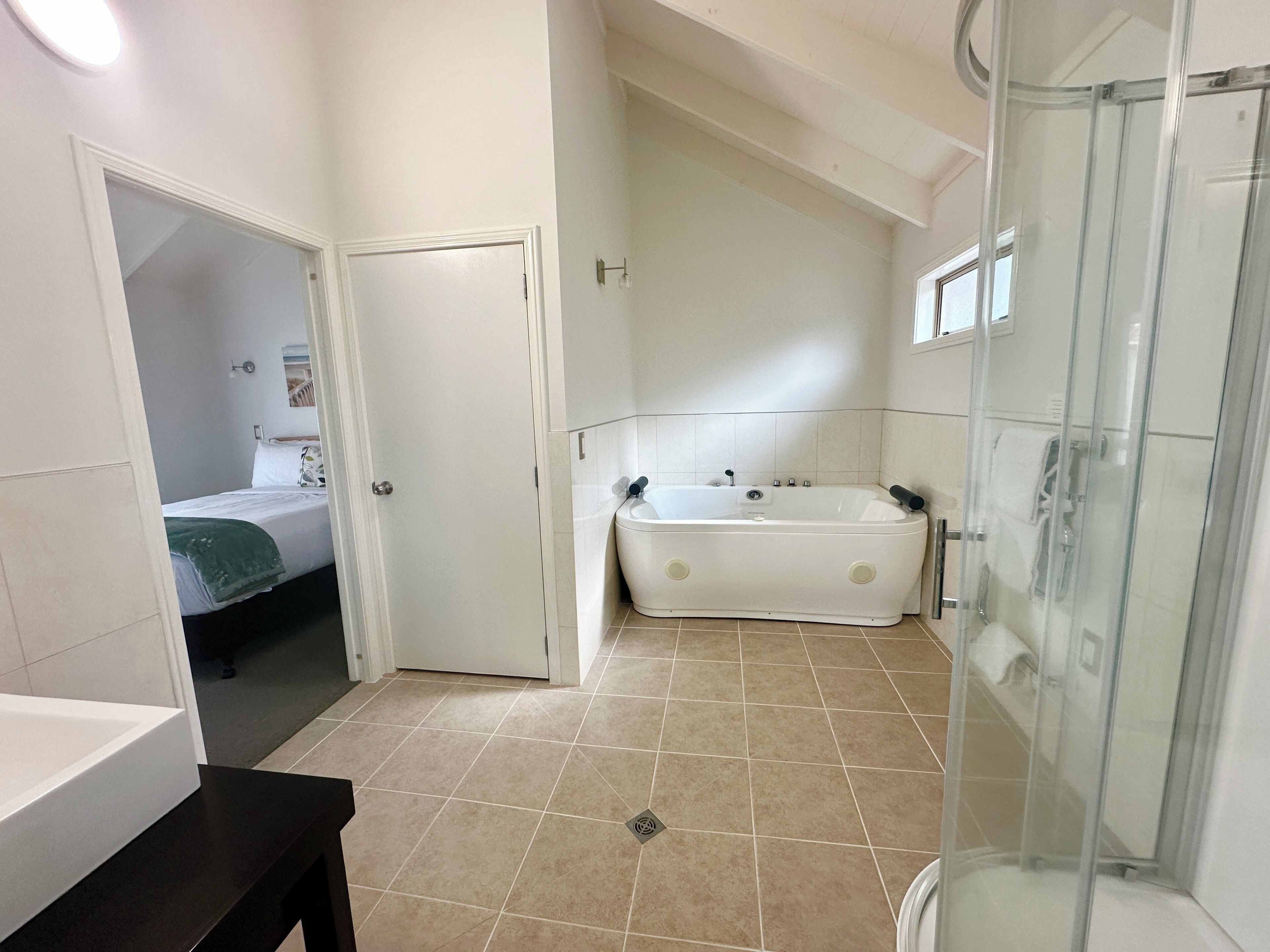 Un baño con bañera, cabina de ducha de vidrio y un inodoro.