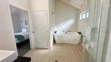 Un baño con bañera, cabina de ducha de vidrio y un inodoro.