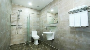 A modern bathroom with a glass-enclosed shower, a toilet, and a sink. - Benikea Central Hotel (Tongyeong)
