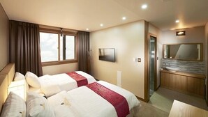 A hotel room with two beds, a TV, a mirror, and a bathroom with a shower. - Benikea Central Hotel (Tongyeong)
