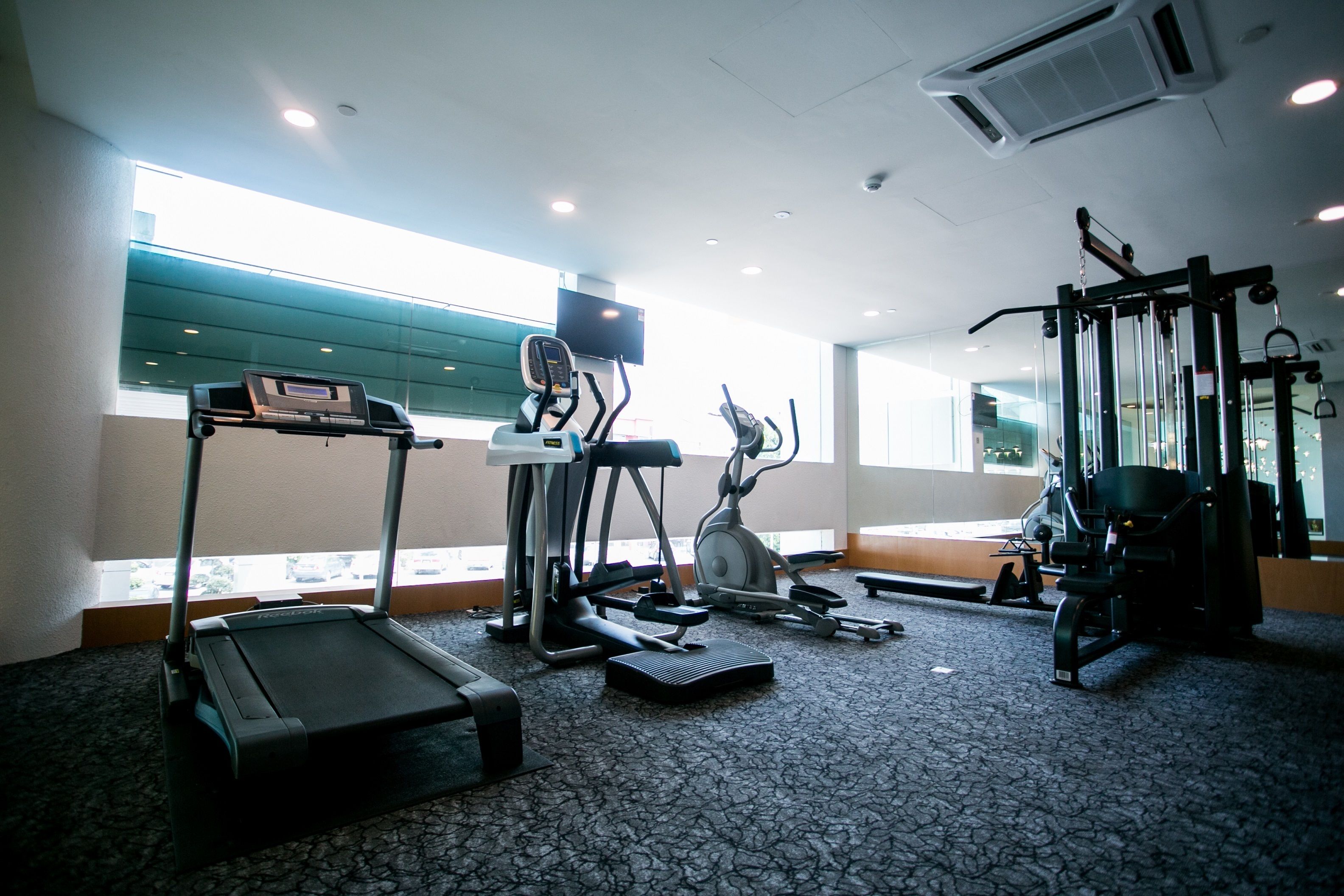 A gym with treadmills, elliptical machines, and weight equipment.