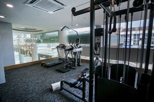 Una palestra con tapis roulant, ellittiche e attrezzature per pesi.